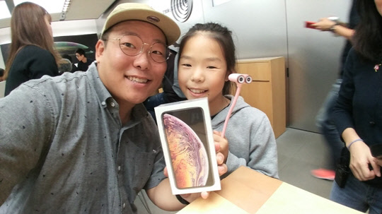 유튜브 크리에이터 송태민 씨 (예명 어비)가 21일 오전 8시 후쿠오카 애플스토어에서 키즈 크리에이터로 활동중인 딸 루피나(예명)와 함께 아이폰XS Max 수령 인증을 하고 있다. <송태민 씨 제공>